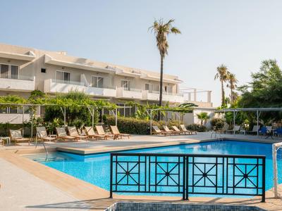Piscina moderna dell'hotel con lettini e palme in una giornata soleggiata.