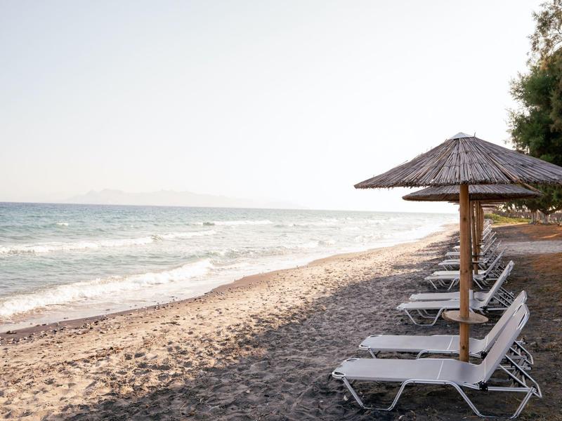 Spiaggia con lettini e ombrelloni sul mare calmo sotto un cielo sereno