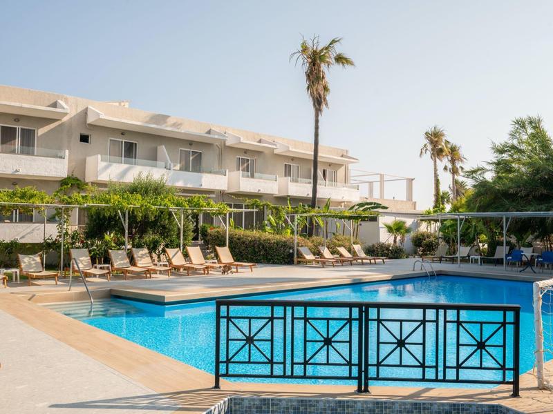 Piscina dell'hotel con lettini e palme sotto un cielo sereno