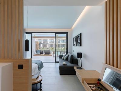 Moderne Hotelzimmer mit Doppelbett, Sitzbereich und Balkon mit Blick auf Innenhof.