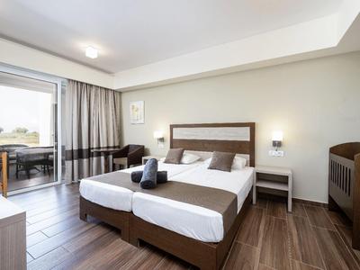 Helles Hotelzimmer mit Doppelbett, Schiebetür zum Balkon und modernem Holzboden.