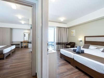 Modern eingerichtetes Hotelzimmer mit zwei Schlafzimmern, Holzfußboden und großen Fenstern.