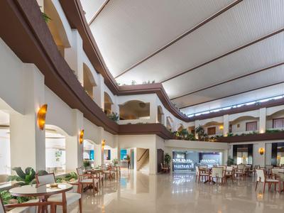 Offener Hotellobbybereich mit Sitzgelegenheiten und überdachtem Innenhof.