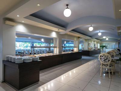 Helles Restaurant mit modernen Möbeln und langen Buffettischen.
