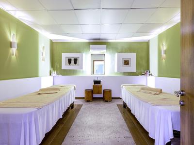 Hell eingerichteter Spa-Raum mit zwei Massageliegen und entspannender Atmosphäre.