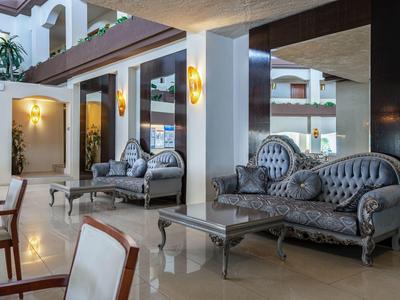Elegante Lobby mit klassischen grauen Sofas, Glastischen und warmem Wandlicht.