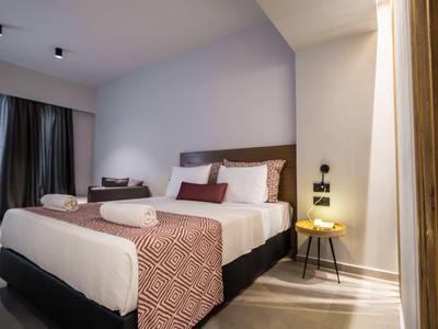 Modernes Schlafzimmer mit Doppelbett, braun-weißem Bettzeug, Nachttisch und Vorhängen am Fenster.