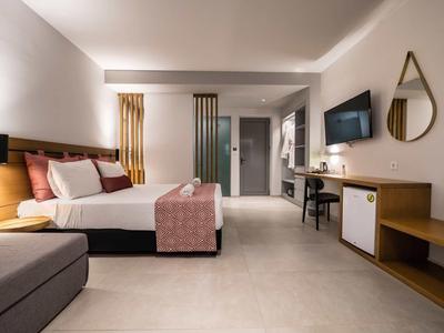 Modernes Hotelzimmer, großes Doppelbett, Fernseher, Schreibtisch, große Fenster, helle Farben, minimalistisch.