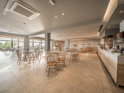 Helles, modernes Hotelrestaurant mit Holzmöbeln und großem Buffetbereich.