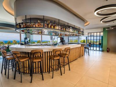 Modernes Hotelbar-Interieur mit großem, halbkreisförmigem Tresen und stilvollen Hockern.
