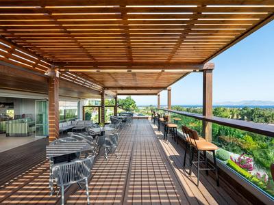 Große Terrasse mit Pergola bietet Ausblick auf Grünflächen und Wasser, ideal für Urlaubsgäste.