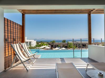 Blick von einer überdachten Terrasse mit Liegestühlen auf einen Pool und das Meer am Horizont.