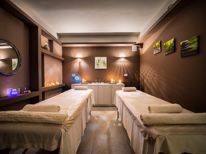 Knusse spa kamer met twee massagetafels, zachte verlichting en rustgevende bruine muren.