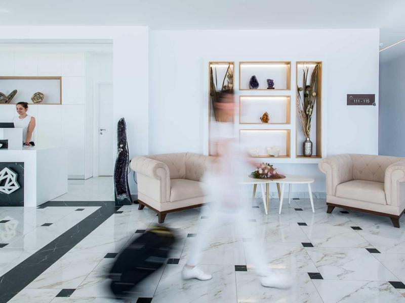 Hol hotelowy z recepcją, wygodnymi sofami i marmurową posadzką