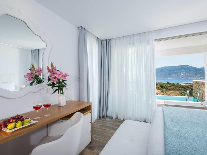 Nowoczesny pokój hotelowy z biurkiem, krzesłem i panoramicznym oknem z widokiem na góry.