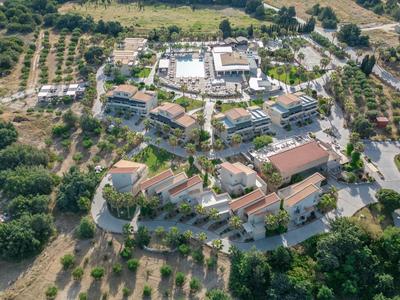 Luftaufnahme eines Hotels umgeben von Olivenhainen mit Straße und Parkplätzen.