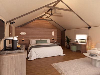 Bequemes Doppelbett in einem modernen, hellen Hotelzimmer mit Holzvertäfelung und Deckenventilator.