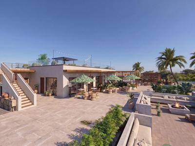 Große Hotelterrasse mit Sitzbereichen, Sonnenschirmen und Palmen unter klarem Himmel.
