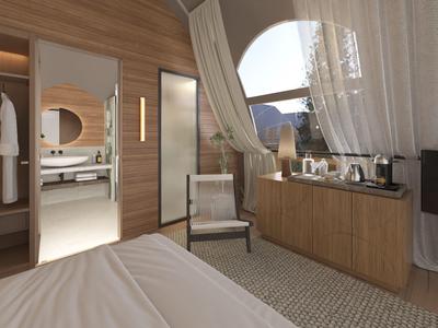 Moderní hotelový pokoj s dřevěnými stěnami, pohodlnou postelí, křeslem a velkým oknem s výhledem na hory.