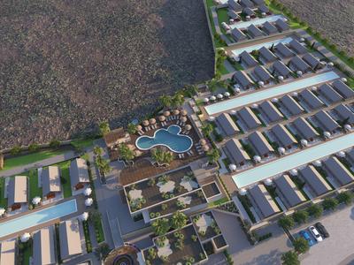 Letecký pohled na moderní resort s mnoha řadovými domy a centrálním bazénem