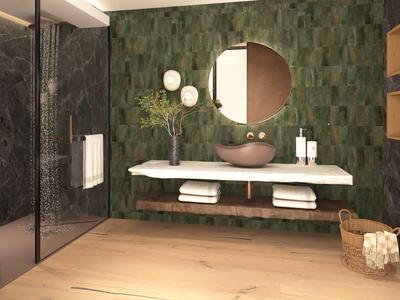 Moderní koupelna se zelenými obklady, kulatým zrcadlem a závěsným umyvadlem.