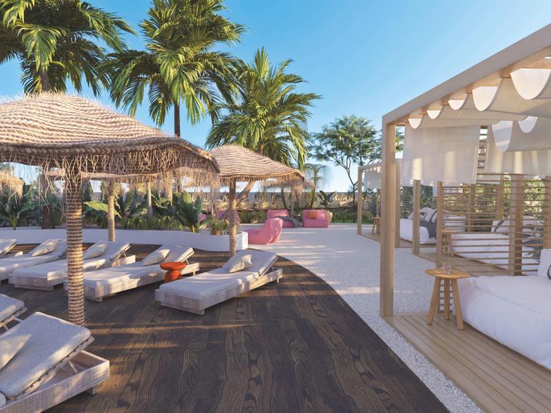 Luxusní venkovní prostor s lehátky, slunečníky a lounge u palm.