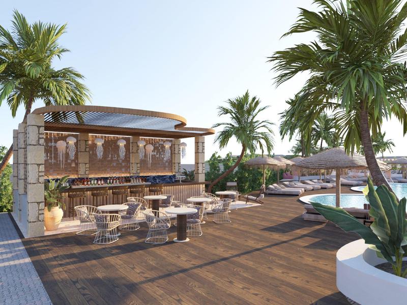 Moderní venkovní prostor s barem, dřevěnou terasou, posezením a palmami pod jasnou oblohou.