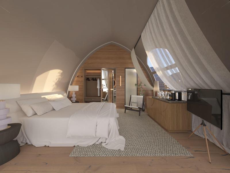 Moderní hotelový pokoj s manželskou postelí, dřevěným obložením a televizí na šikmé stěně.