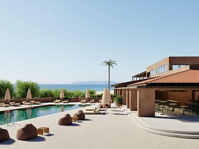 Área de piscina moderna con tumbonas, sombrillas y vista al mar bajo un cielo azul claro.