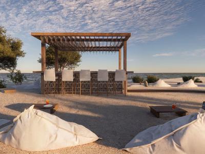Strandbar met zitplaatsen, wit zandstrand en kalme zee onder een bewolkte hemel.