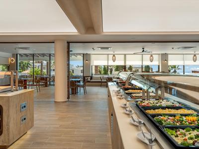 Hotel buffet area with various salads and dishes displayed on long counters.