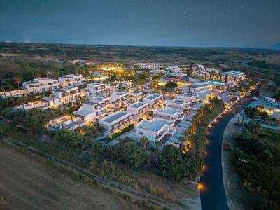 Aerial view of a lit hotel complex at night in a rural area.