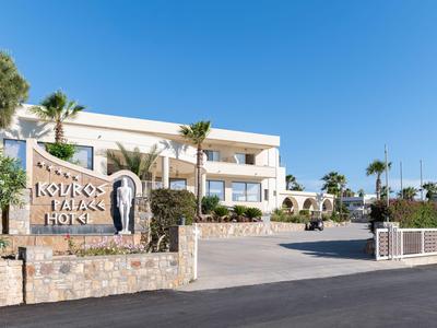 Modern hotel complex with white building, palm trees, and clear blue sky.