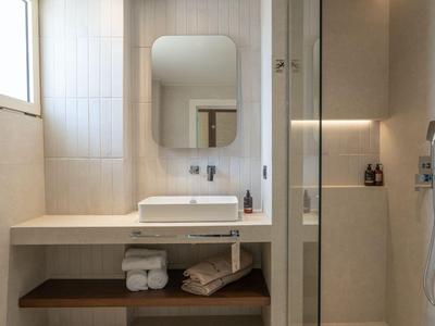 Modern bathroom with rectangular sink, large mirror, and walk-in shower.