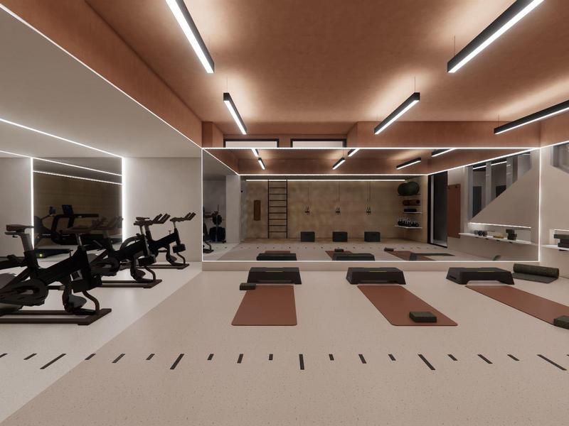 Gimnasio moderno bien iluminado con bicicletas, esterillas de yoga y pesas.
