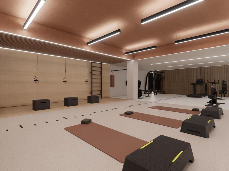 Gimnasio moderno con esterillas de yoga, step y pesas en un interior luminoso con pared de espejo.