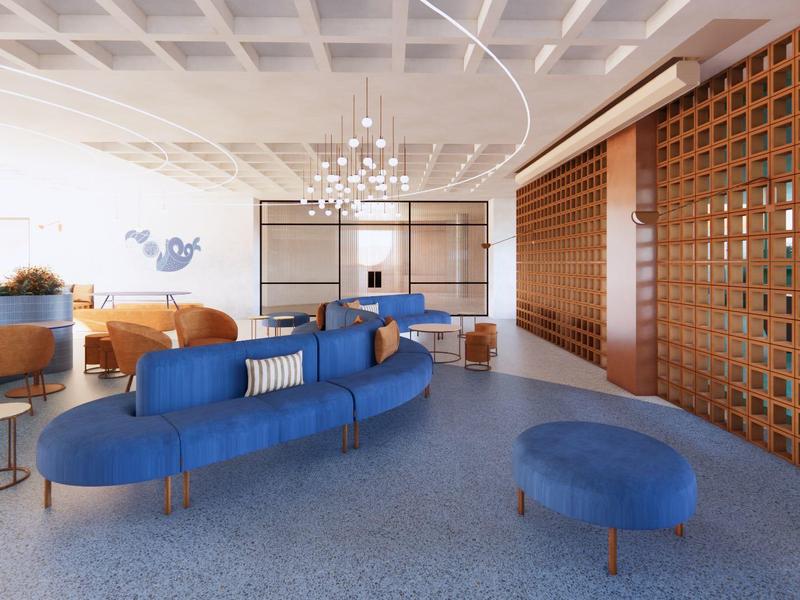 Moderna recepción de hotel con sofás azules, paredes de madera y candelabro.