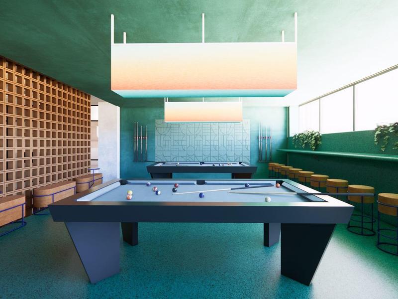 Sala de juegos moderna con mesa de billar, taburetes de madera y ambiente verde brillante.