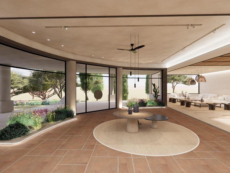 Amplia zona lounge moderna de hotel con alfombras redondas y ventanas de suelo a techo.