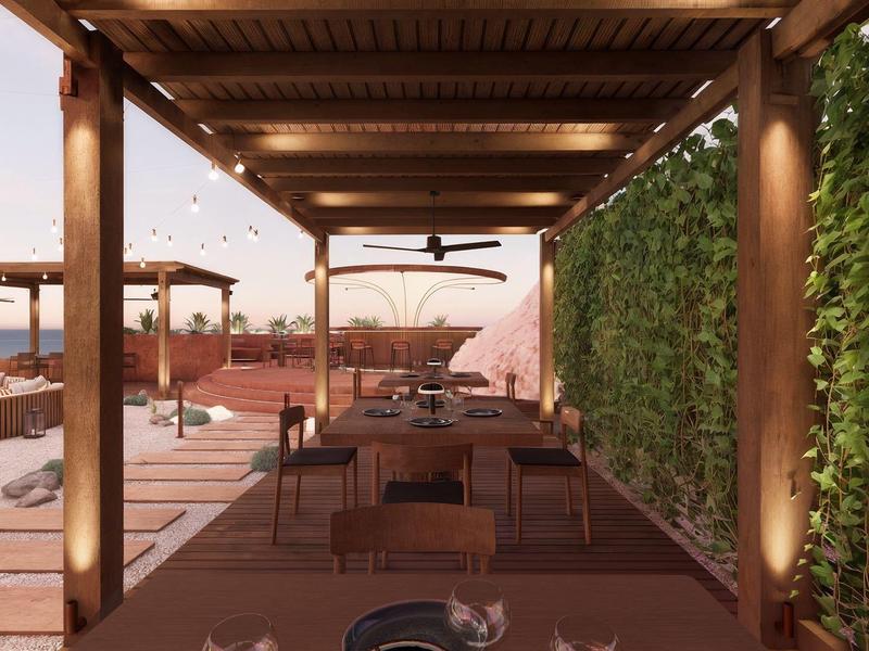 Restaurante al aire libre con mesas preparadas bajo un pabellón de madera y pared verde al fondo