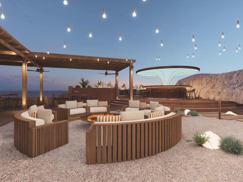 Área exterior moderna con asientos y luces colgantes al anochecer en un hotel