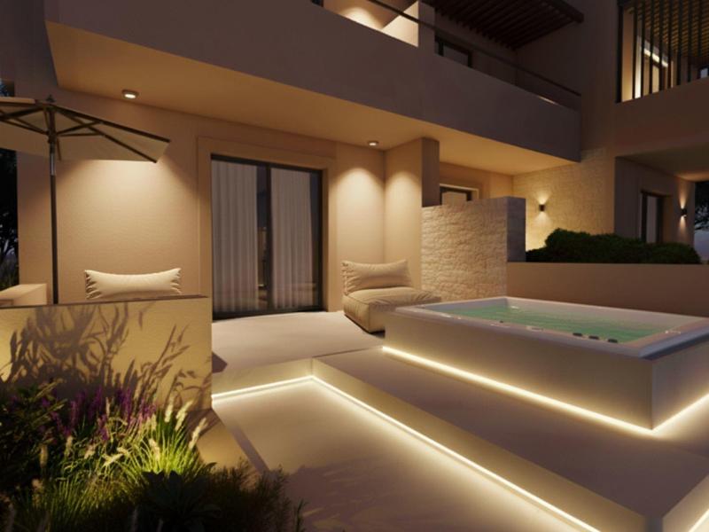 Terraza moderna con jacuzzi iluminado y áreas de descanso al anochecer.