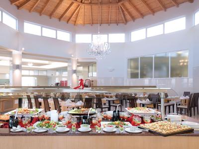 Großer Buffetbereich in einem hellen Restaurant mit Holzdecke und verschiedenen Speisen.