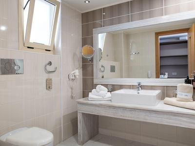 Bagno moderno in hotel con lavandino, specchio e finestra aperta.