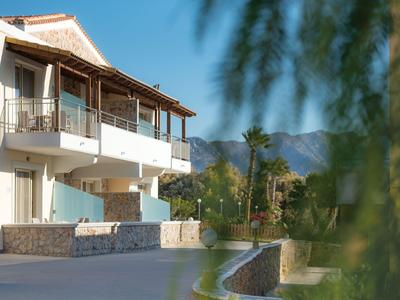 Modernes Hotelgebäude mit Balkonen und Bergblick bei sonnigem Wetter