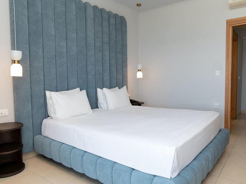 Camera d'hotel moderna con letto grande e testiera blu