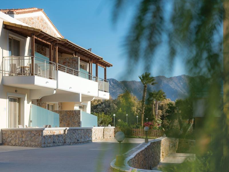 Bungalow moderno con terrazza e vista sulle montagne sotto un cielo azzurro.