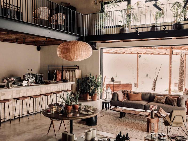 Moderner, gemütlicher Wohnraum mit Sofas, Holzmöbeln, großer Lampe und Blick auf Terrasse.