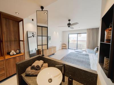Helles Hotelzimmer mit Doppelbett, großem Spiegel und Balkon mit Ausblick.