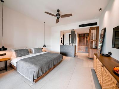 Helles Hotelzimmer mit Doppelbett, Deckenventilator und moderner Einrichtung.